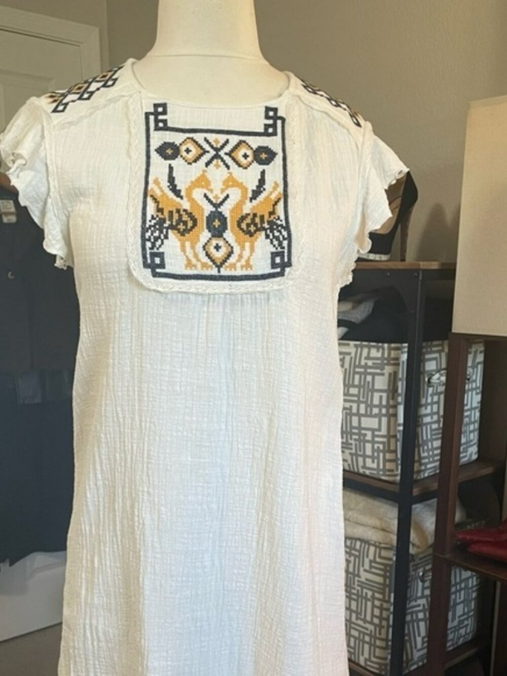 White cotton gauzy knee length dress with lace and embroidery. Flutter sleeve
